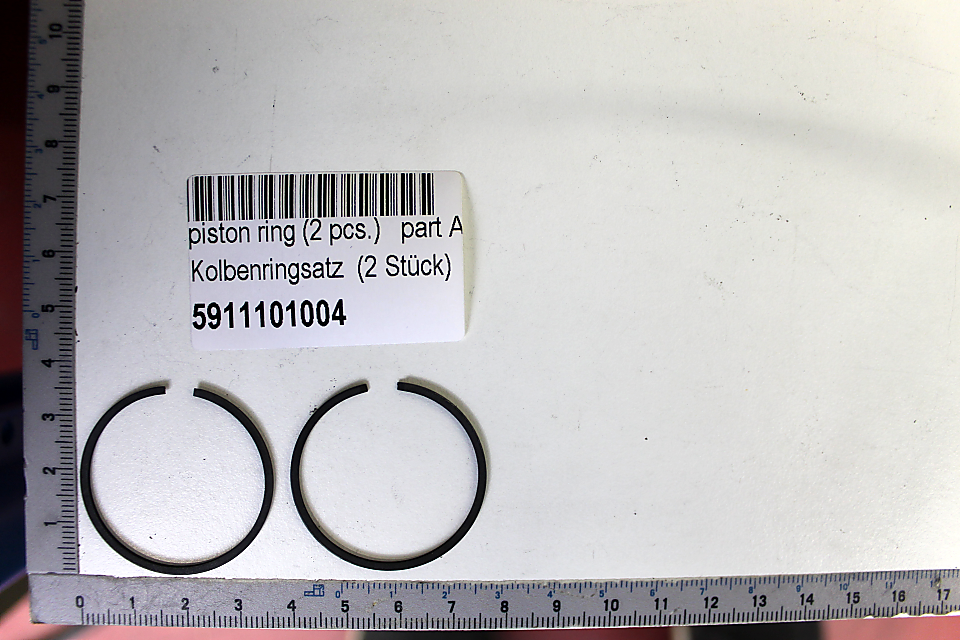 Kolbenringsatz (2 Stück) mit der Artikelnummer 5911101004. Die Ringe sind nebeneinander auf einem Lineal liegend dargestellt.