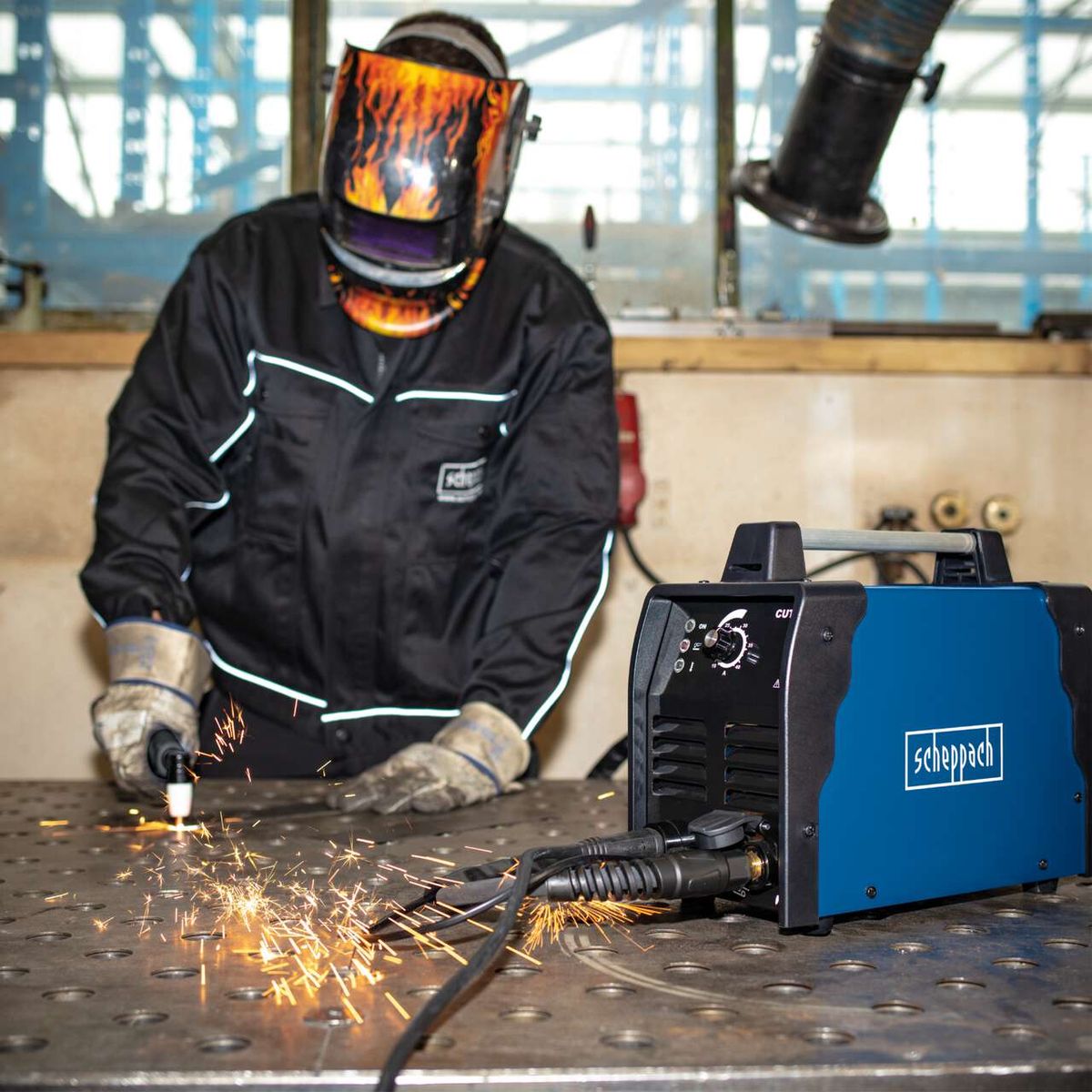 Plasmaschneider PLC40 mit 12 mm Schnittstärke, 2,5 m Schneidkabel und inkl. Druckluftschlauch. Gezeigt wird die Anwendung des Plasmaschneiders an einer Metallplatte.