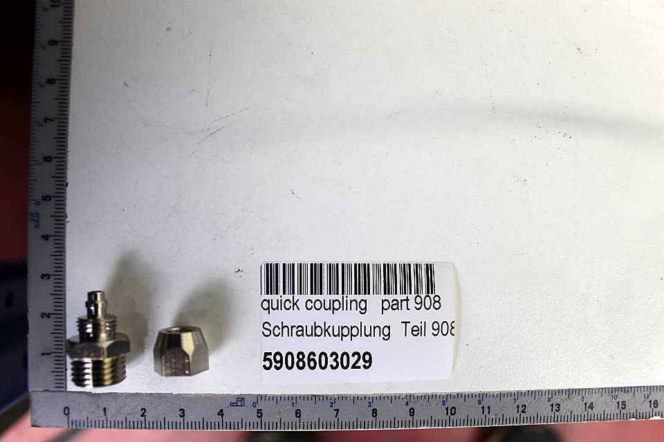 Ein Scheppach-Quick-Coupling Teil 908 mit der Artikelnummer 5908603029. Zwei Metallteile sind neben einem Maßstab mit Zentimeter- und Millimeterangaben abgebildet.
