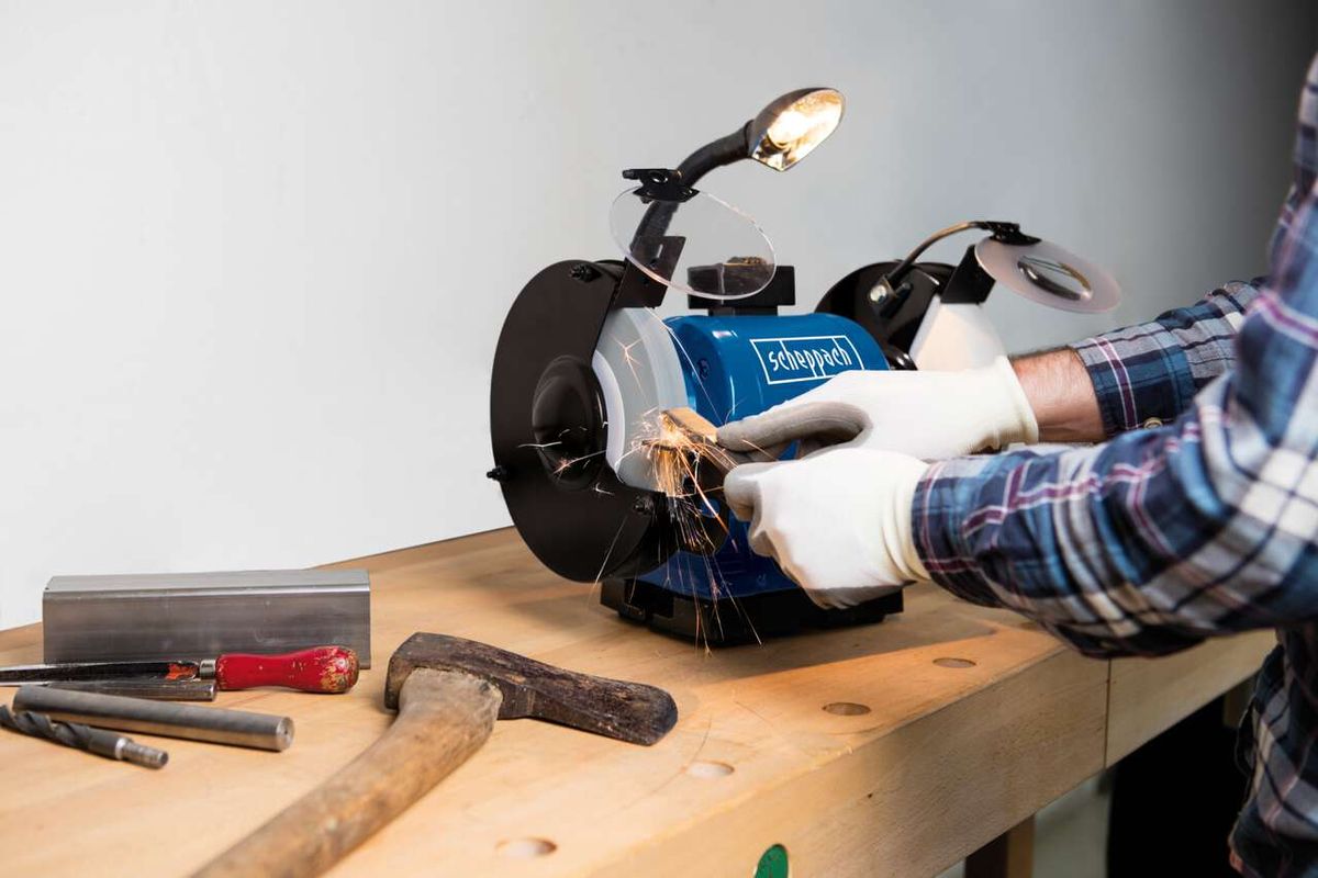 Scheppach-Doppelschleifer mit Arbeitshandschuhen und Schutzbrille beim Einsatz auf Werkstück