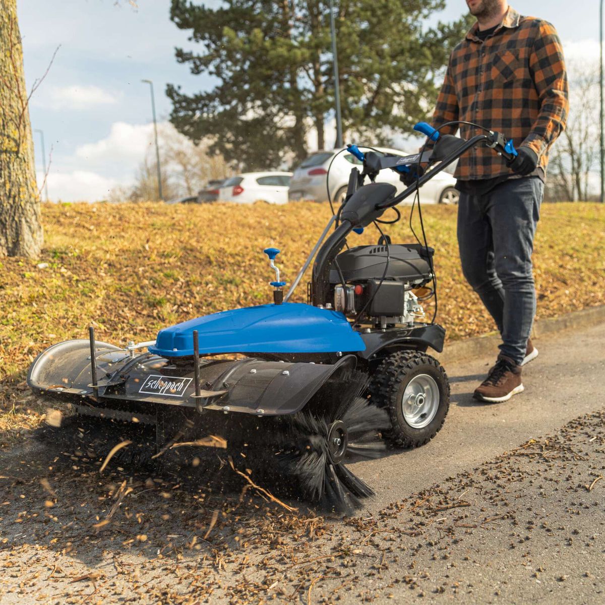 Scheppach Kehrmaschine mit Sammelbehälter und Schneeschild, Detailansicht mit Bedienelementen und Antriebseinheit