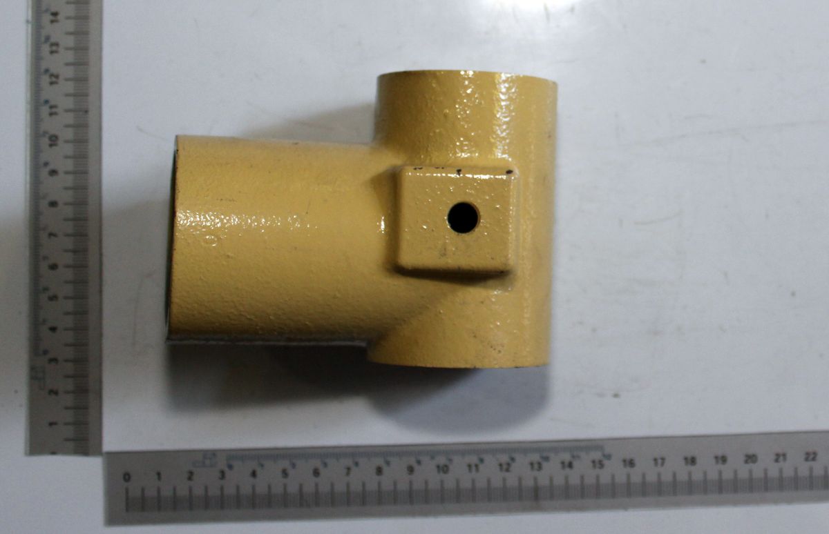 Ein gelbes Lagerstück mit einem zylindrischen und einem quadratischen Ende. Das quadratische Ende hat eine Bohrung. Das Teil wird von der Seite gezeigt.