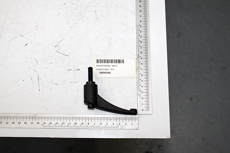 Ein Spezialgriff, Teil 3, Artikelnummer 1902501003, neben einem Lineal zur Größenveranschaulichung.