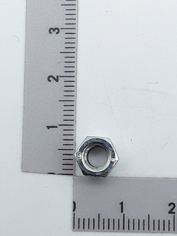 Sechskantmutter M5 selbstsichernd, von vorne fotografiert, neben einem Lineal zur Größenveranschaulichung.