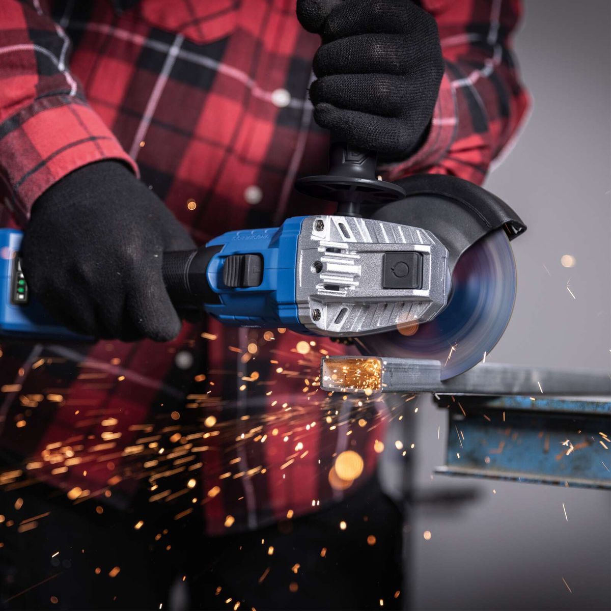 }Akku-Winkelschleifer mit Schutzglas für präzise Bearbeitung, Spiralnuten für bessere Handhabung und integrierte Sicherheitsmerkmale bei Arbeit mit Metallspänen.