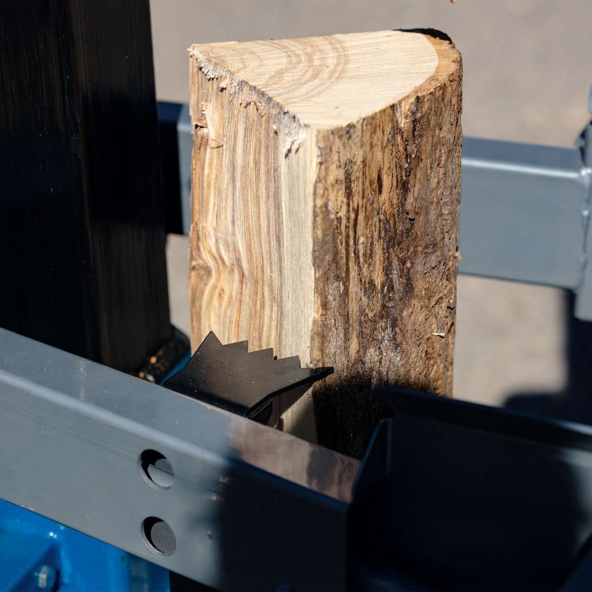 Scheppach-Meterholzspalter mit Holzstück zwischen Anpressfuß und Schneide