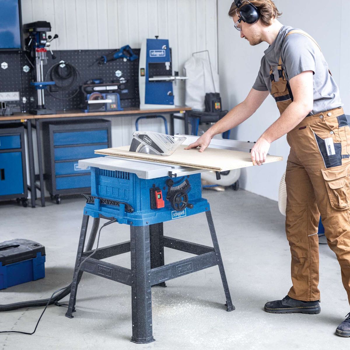 Scheppach Tischkreissäge HS105 mit Arbeitsplatte und Bedienperson, die Material ausrichtet