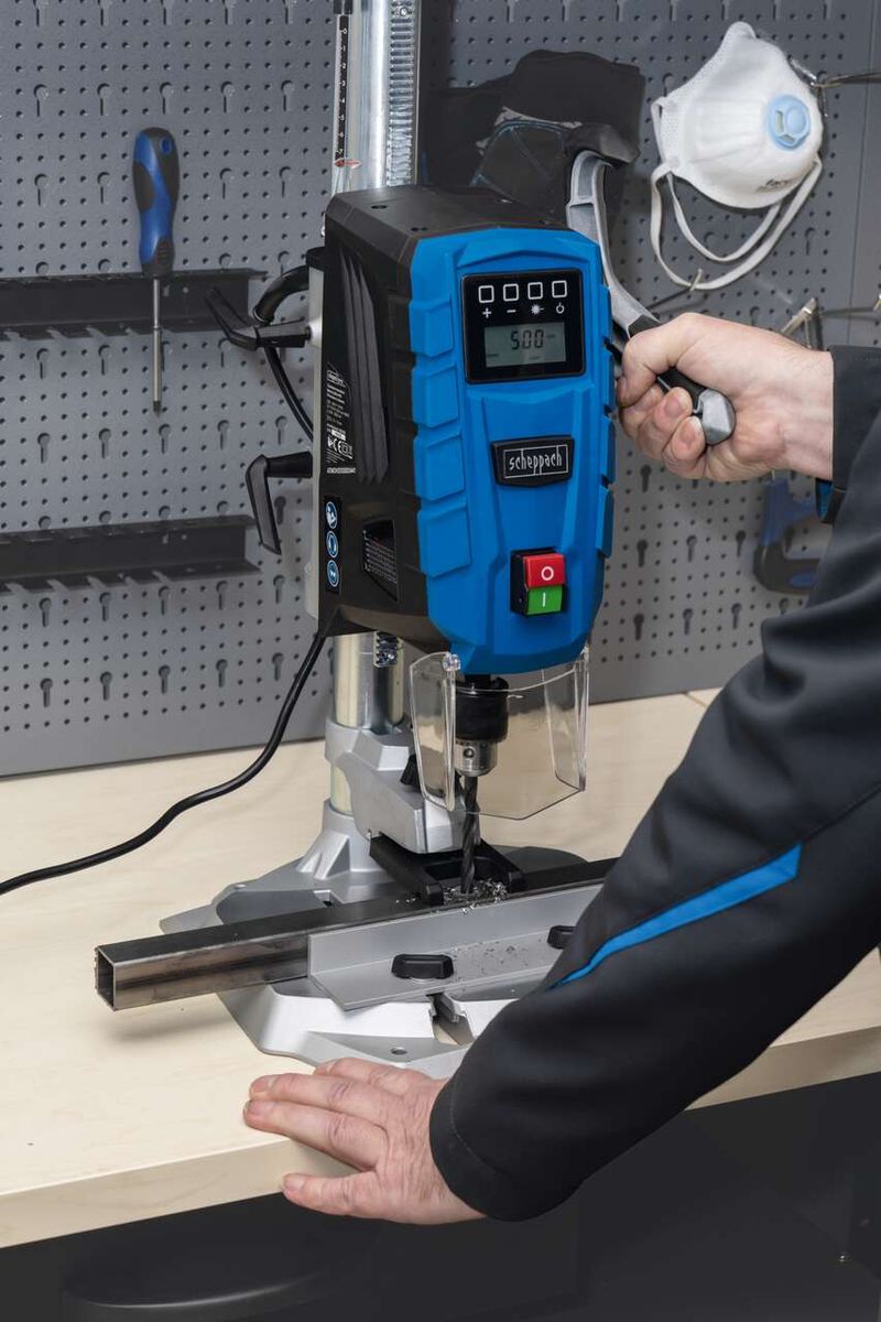 Scheppach Tischbohrmaschine DP55 im Einsatz. Ein Arbeiter bedient die Bohrmaschine an einem Metallstück. Die Maschine hat eine digitale Anzeige mit 580 U/min.