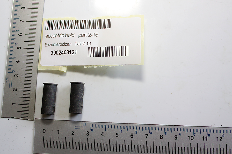 Exzenterbolzen Teil 2-16, Artikelnummer 3902403121, zwei Bolzen von vorne neben einem Lineal.