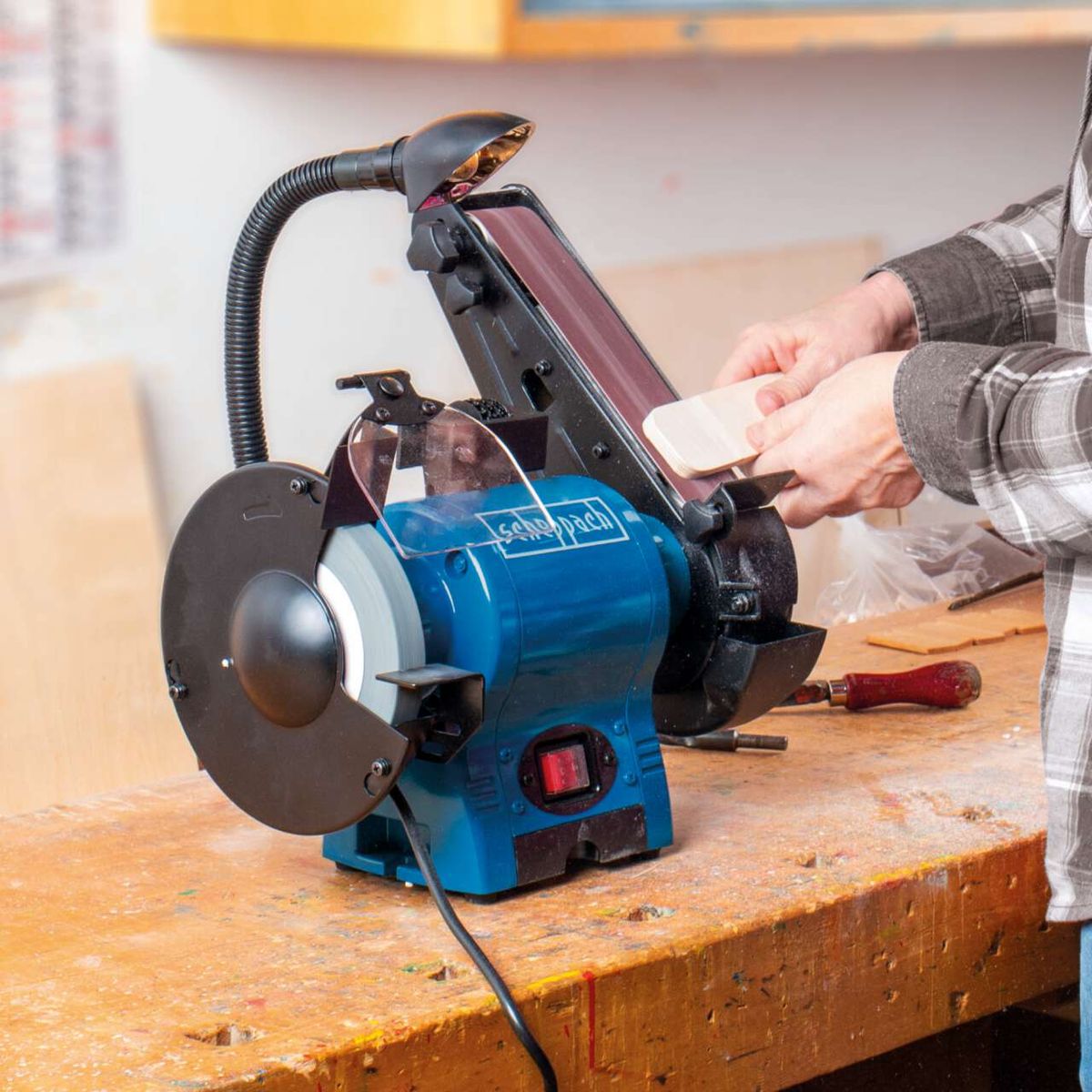 The BGS700 combination grinder by Scheppach with 370W power, 686mm belt length and 50mm width, featuring a 150mm grinding wheel. The machine combines belt and disc grinding.