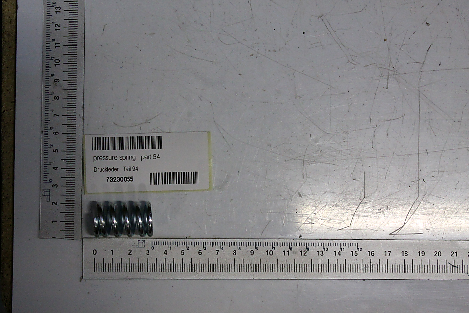 Druckfeder (Teil 94) mit Beschriftung und Barcode auf dem Packband