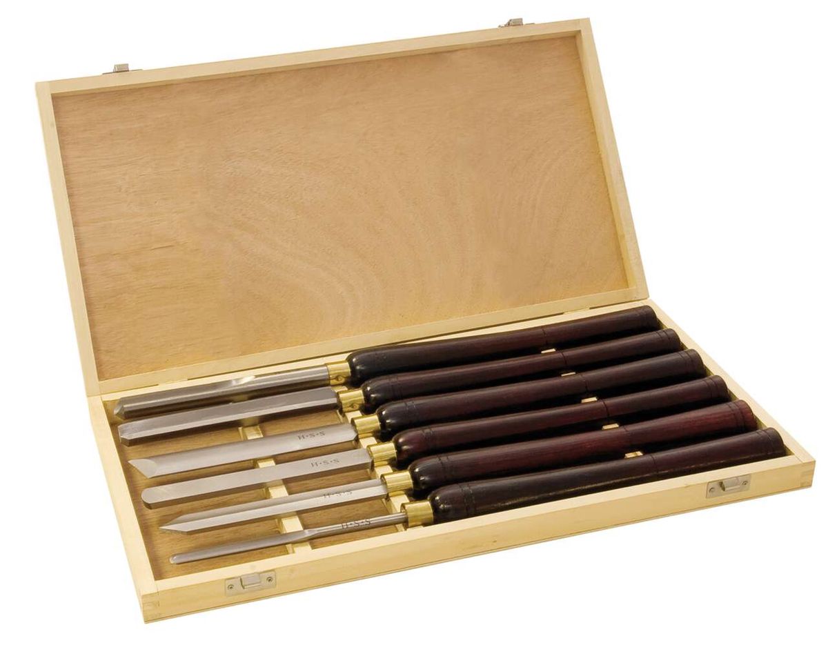 Werkzeugsatz mit sechs verschiedenen Werkzeugen in einem Holzkasten. Die Werkzeuge sind in Scheiden aus Holz oder Kunststoff. Produktname: Werkzeugsatz, 6-fach.