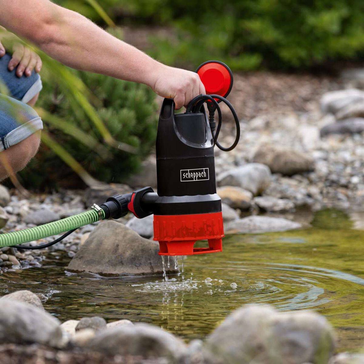 Scheppach-Schmutzwasserkombipumpe mit Handgriff und Wasserauslass im Einsatz