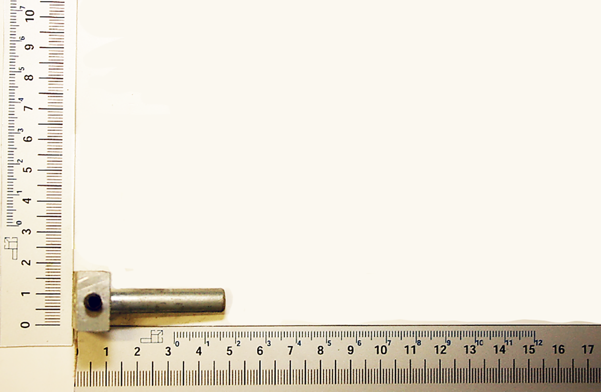 Ein Druckbolzen kpl. von Scheppach neben einem Lineal zur Größenmessung. Der Bolzen ist etwa 5 cm lang.