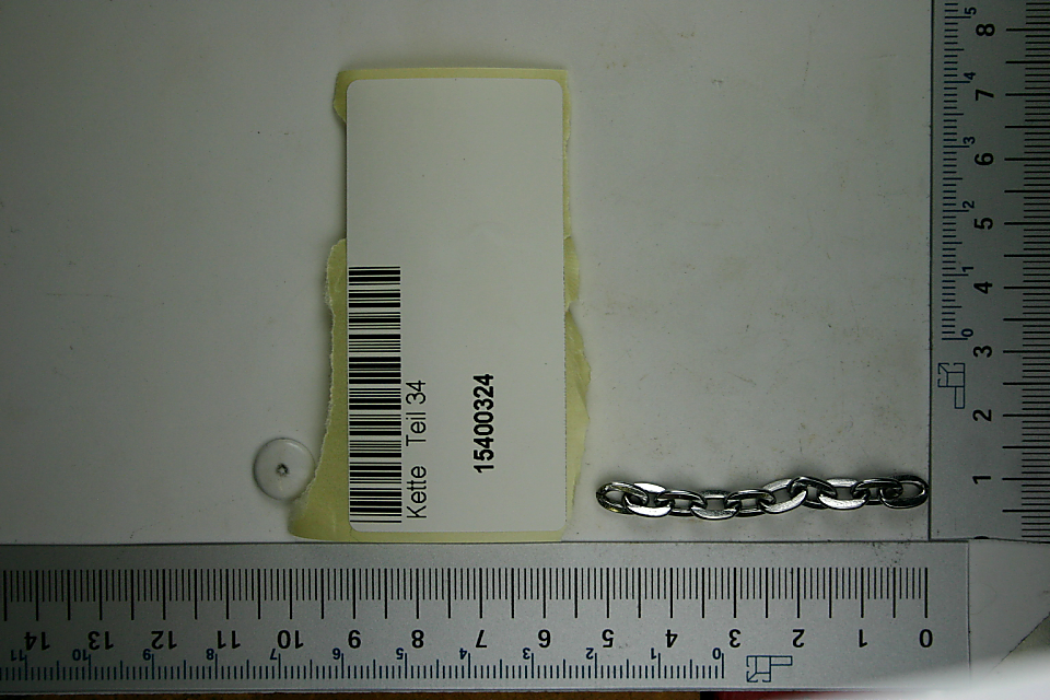 Ein Scheppach-Werkzeug mit der Artikelnummer 15400324. Das Werkzeug ist an einer Kette befestigt und liegt auf einem Lineal zur Größenveranschaulichung.