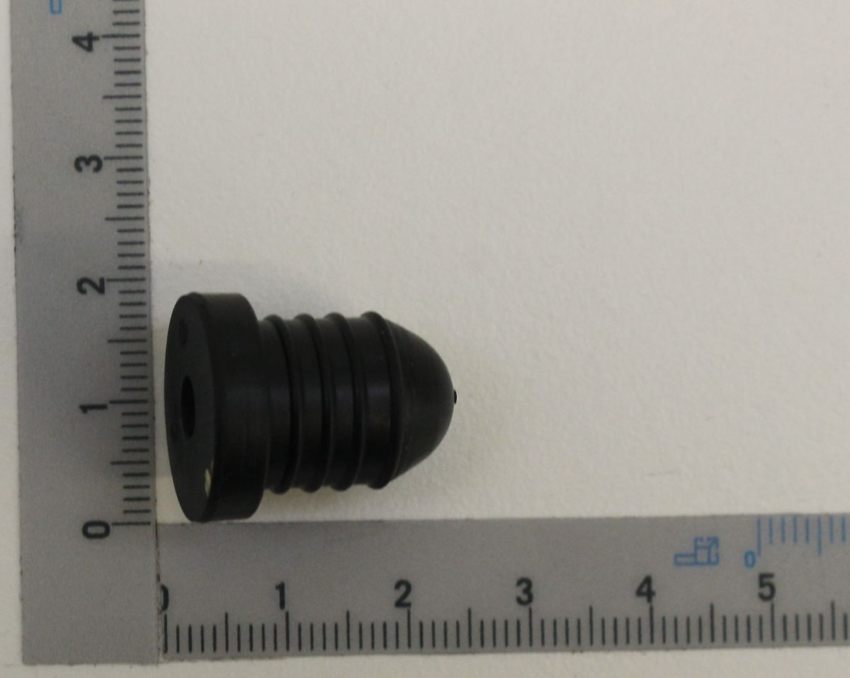 Wasserpumpenstopper, schwarz, geriffelt, neben einem Lineal zur Größenveranschaulichung.
