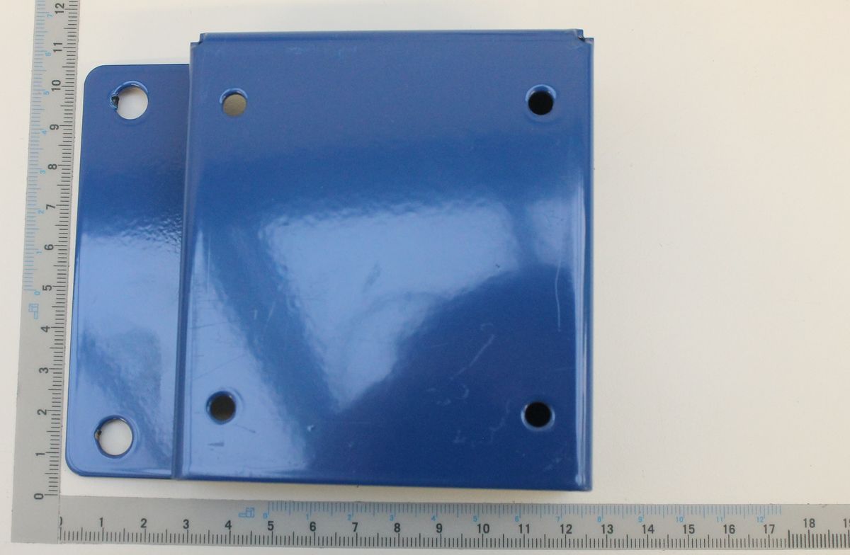 Ein blaues Schalterblech mit drei Löchern, daneben ein Lineal zur Größenveranschaulichung.