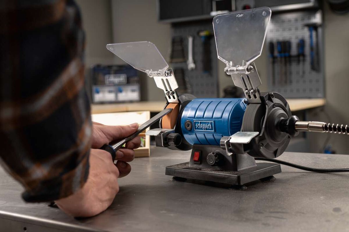 Doppelschleifer HG35 von Scheppach im Einsatz. Ein Benutzer schleift ein Werkstück mit der Maschine. Die Schleifscheiben sind im Vordergrund zu sehen.