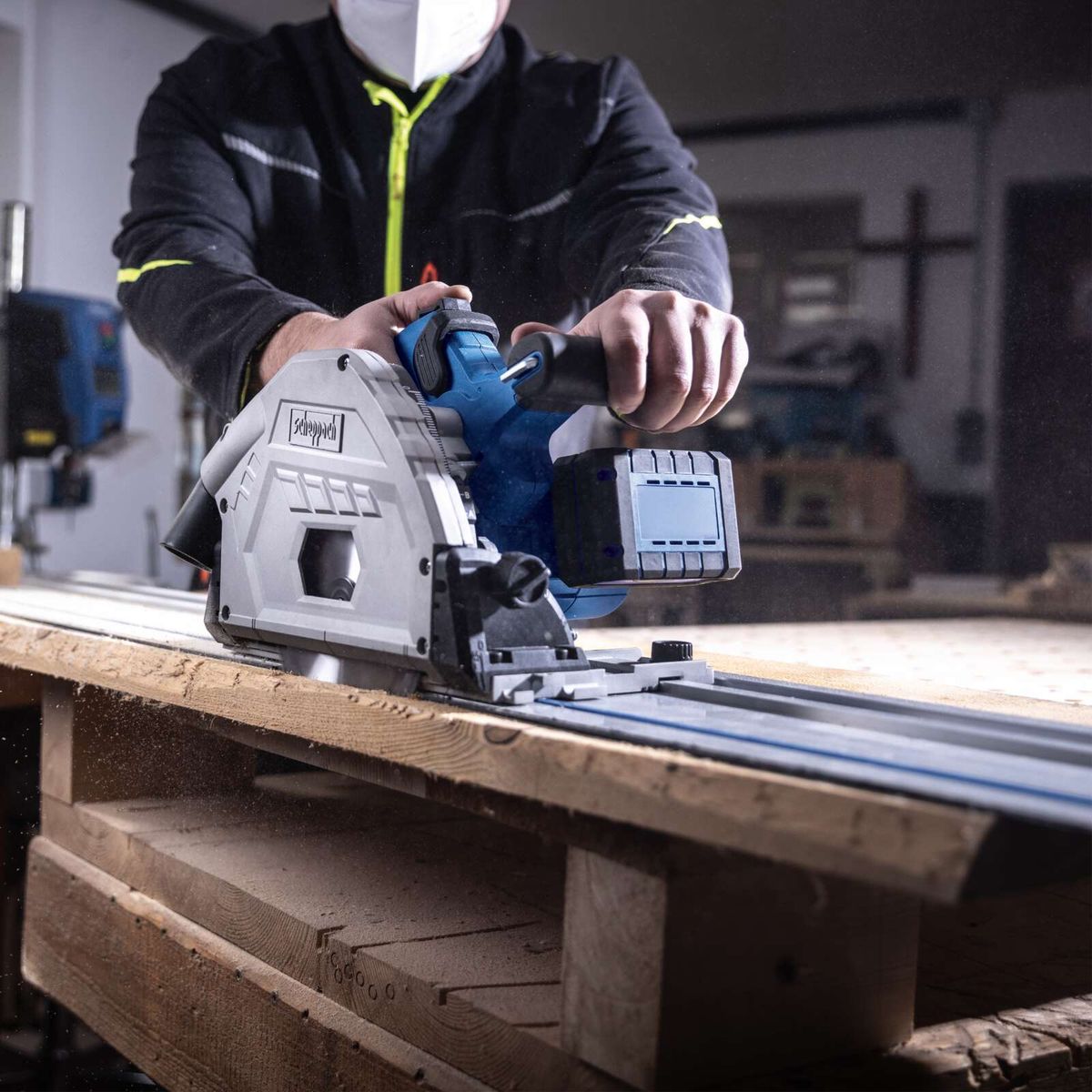 Akku-Tauchsäge mit integriertem Führungssystem beim Schneiden von Holzplatten