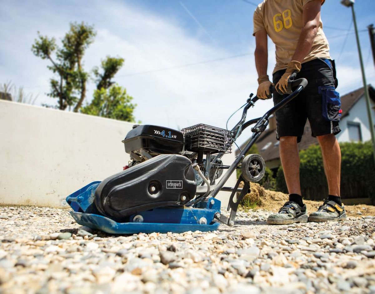 Scheppach-Rüttelplatte HP1300S mit Fahrwerk und Gummimatte, Detailansicht eines Nutzers beim Einsatz