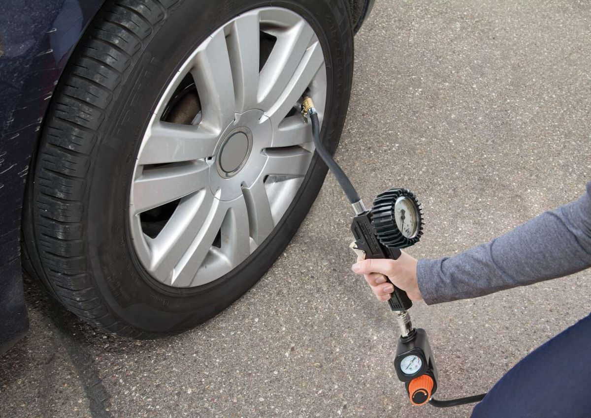 Ein Scheppach-Kompressor wird verwendet, um den Reifendruck eines Autos zu prüfen. Der Kompressor ist mit einem Druckmesser ausgestattet.