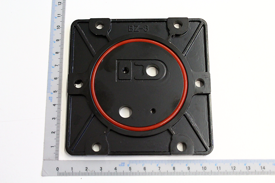 Ventilplatte mit Dichtung, Modell BZ-3, quadratische Form mit vier Befestigungslöchern, rote Dichtung in der Mitte, Maße ca. 10x10 cm.