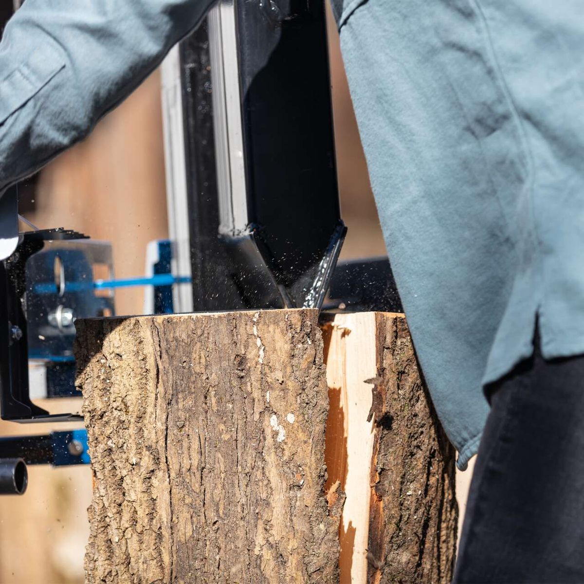 Der Holzspalter Compact 12t von Scheppach zeigt einen robusten Holzblock, der in der Maschine eingespannt ist. Die Maschine ist bereit, den Block zu spalten. Der Holzblock ist etwa 1070mm lang und 450mm breit.
