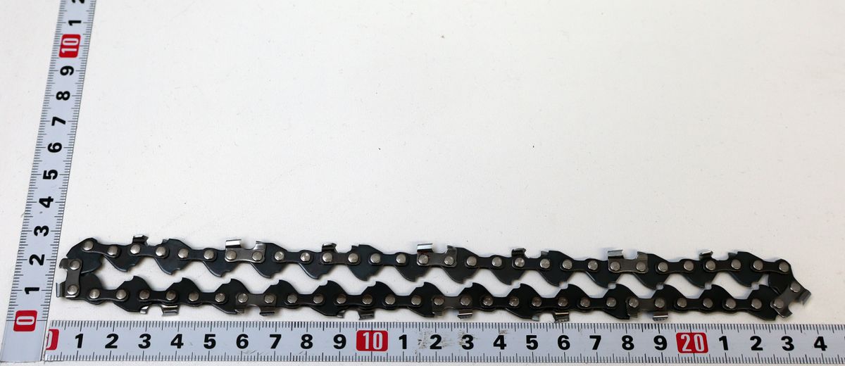 Eine Sägekette mit 15 Schneidzähnen und 31 Antriebsgliedern, gemessen an einem Lineal. Die Kette ist von vorne fotografiert.