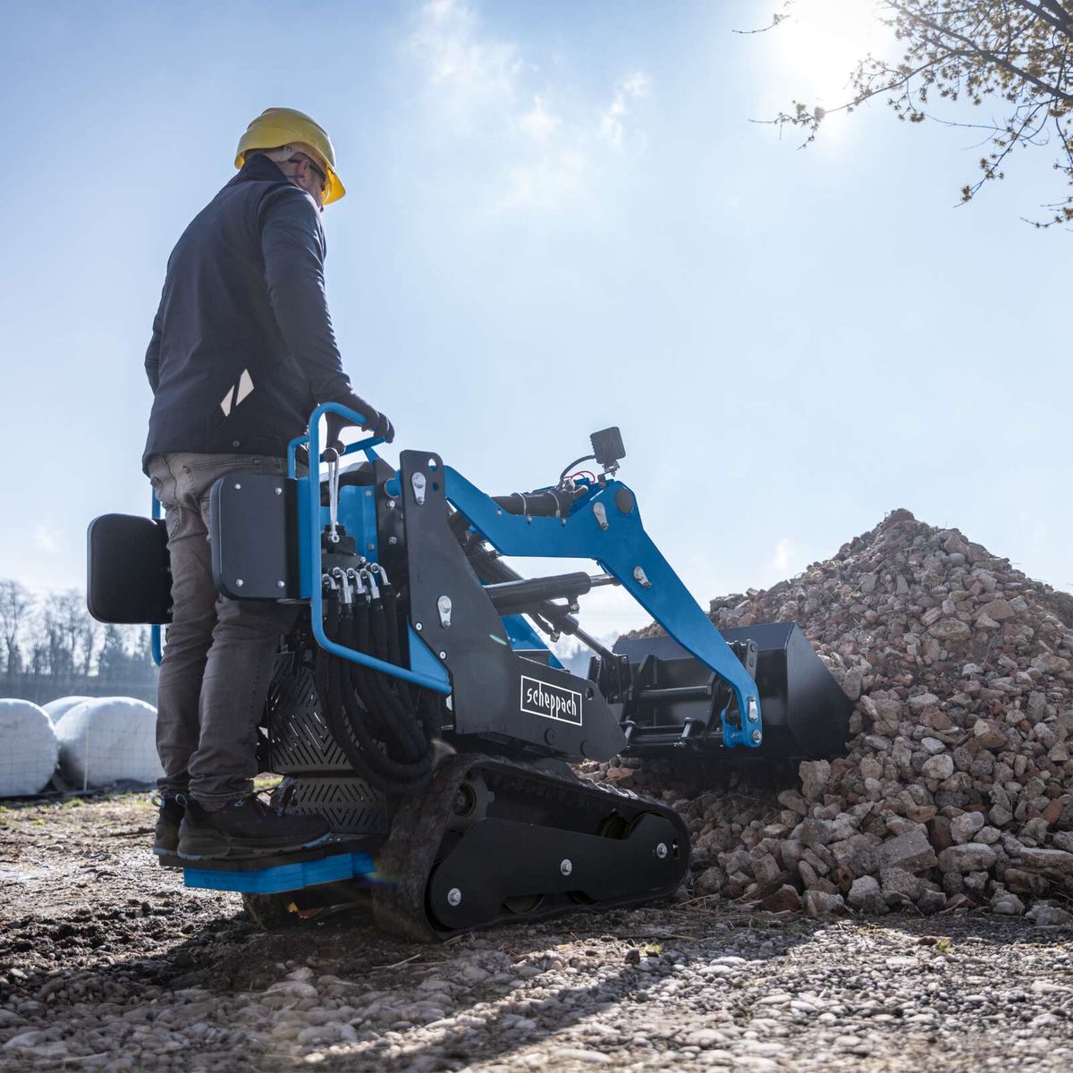 Kompaktladermaschine mit Schaufel und Erdbohrern für Materialhandhabung und Bodenbearbeitung