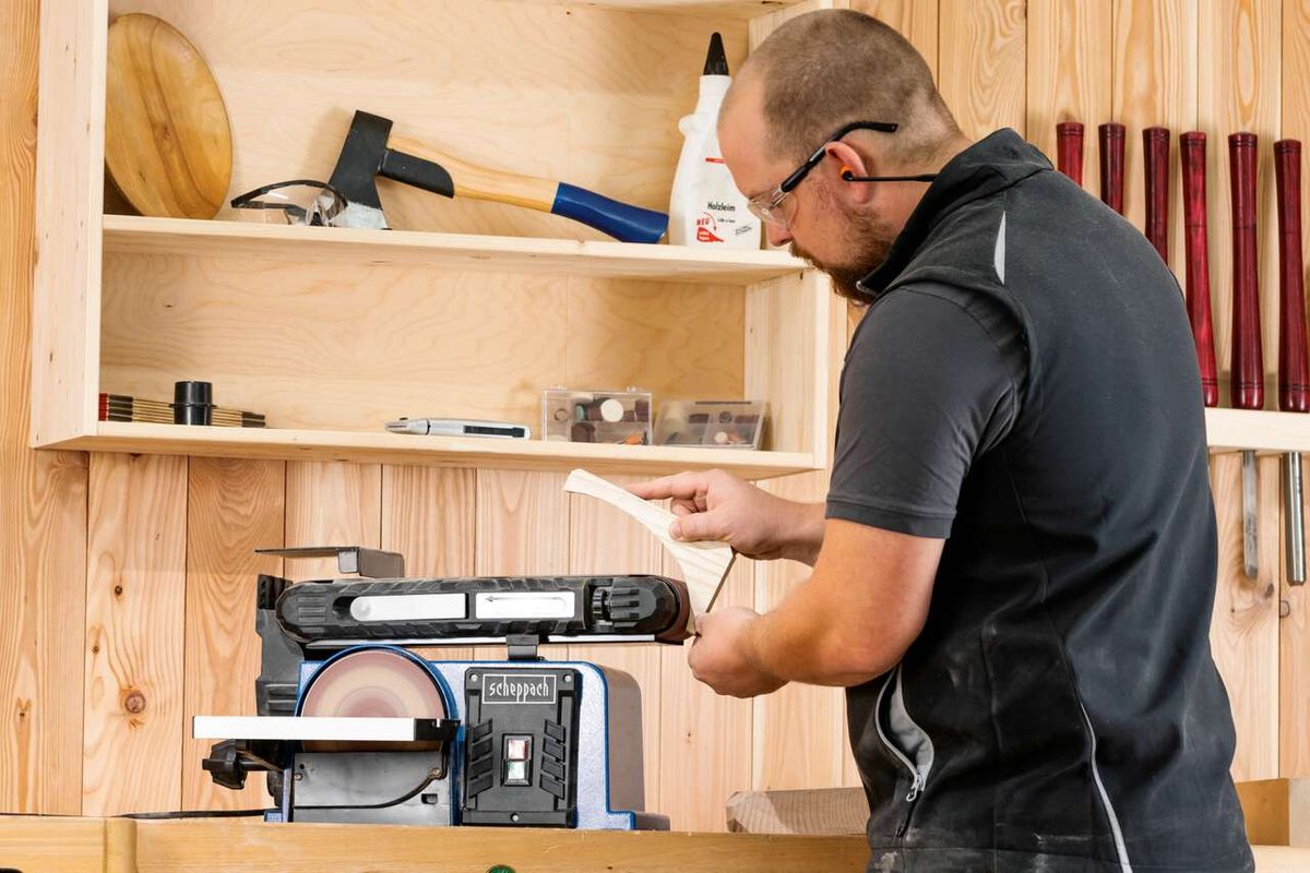 Mann beim Arbeiten mit Scheppach Band- und Tellerschleifer auf Holzarbeitsplatz