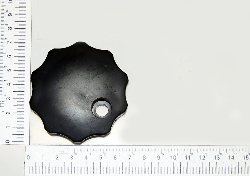 Ein schwarzer Verschluss mit achtseitiger Form und zentraler Öffnung. Das Teil wird von oben gezeigt.