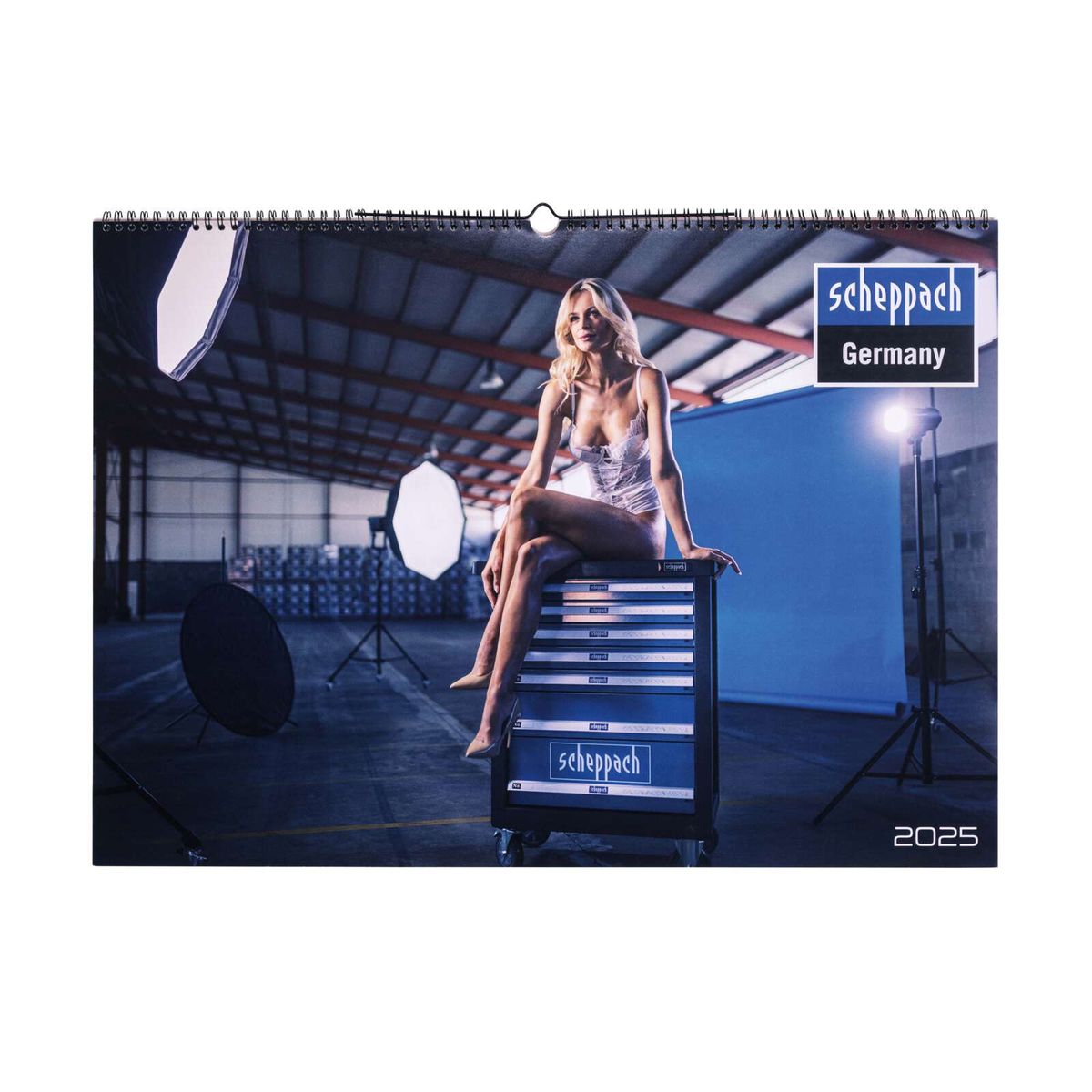 Jahreskalender 2025 Scheppach, Frau sitzt auf Werkzeugwagen, Industriehalle im Hintergrund.