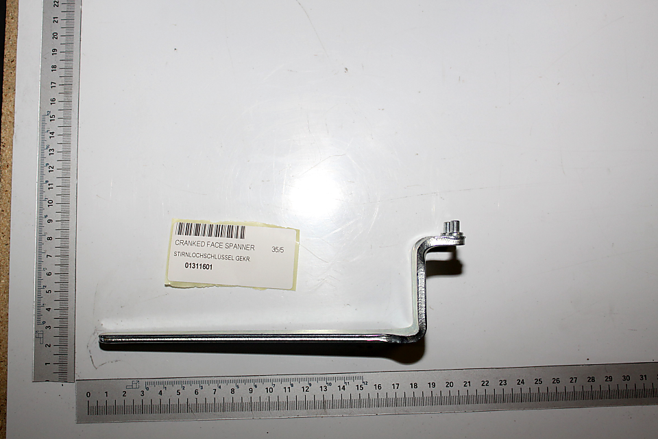 Ein gekröpfter Gabelschlüssel mit der Bezeichnung "STIRNLOCHSCHLÜSSEL GEKR. 35/5" liegt auf einem weißen Hintergrund. Das Werkzeug ist von der Seite zu sehen.