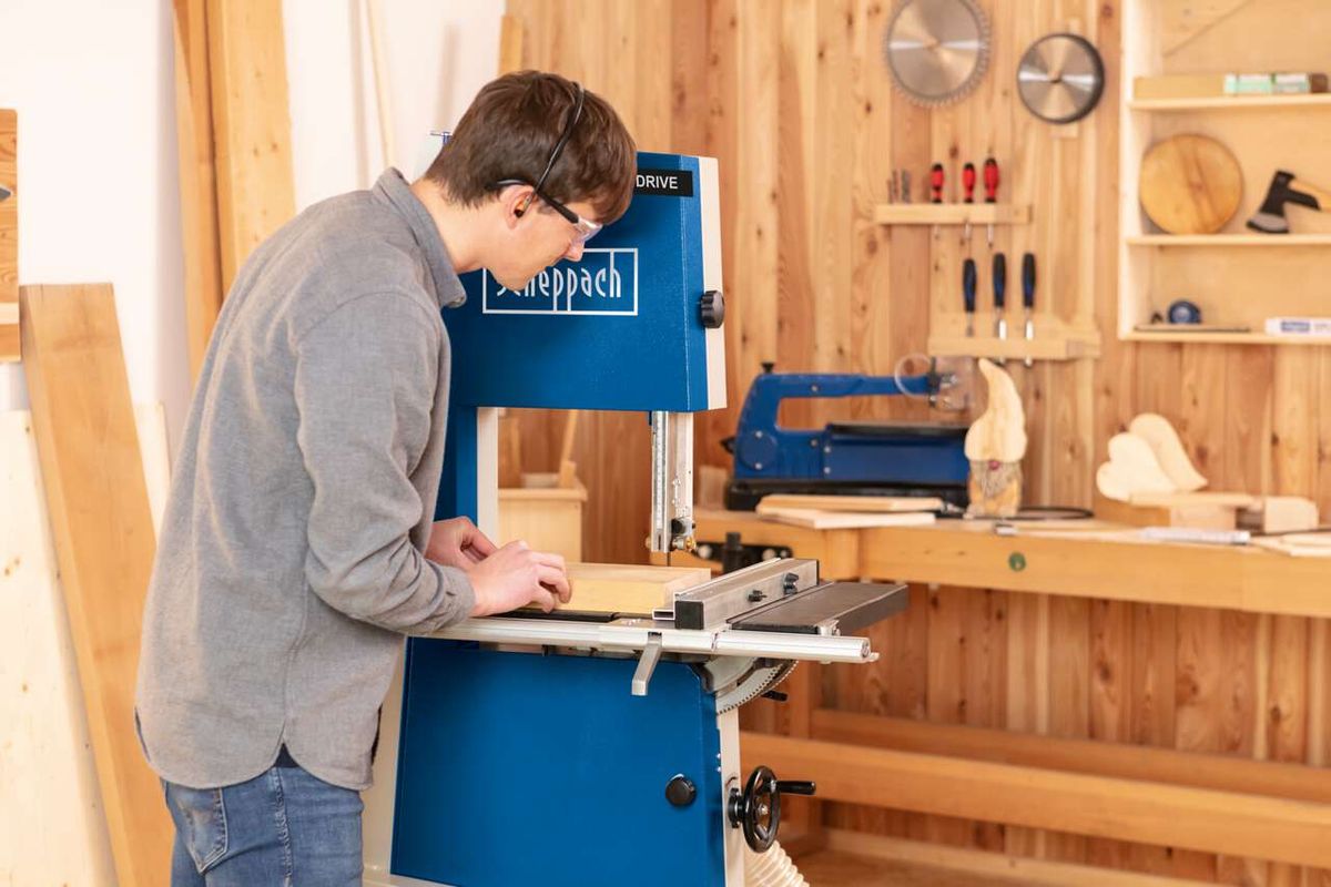 Person arbeitet an einer Bandsäge von Scheppach in einem Werkstattumfeld