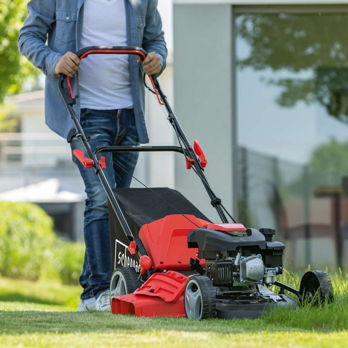 The Scheppach petrol lawnmower MS161-46 features a 46 cm cutting width, self-propelled wheels, and a mulching function. It includes a 55L catcher bag.