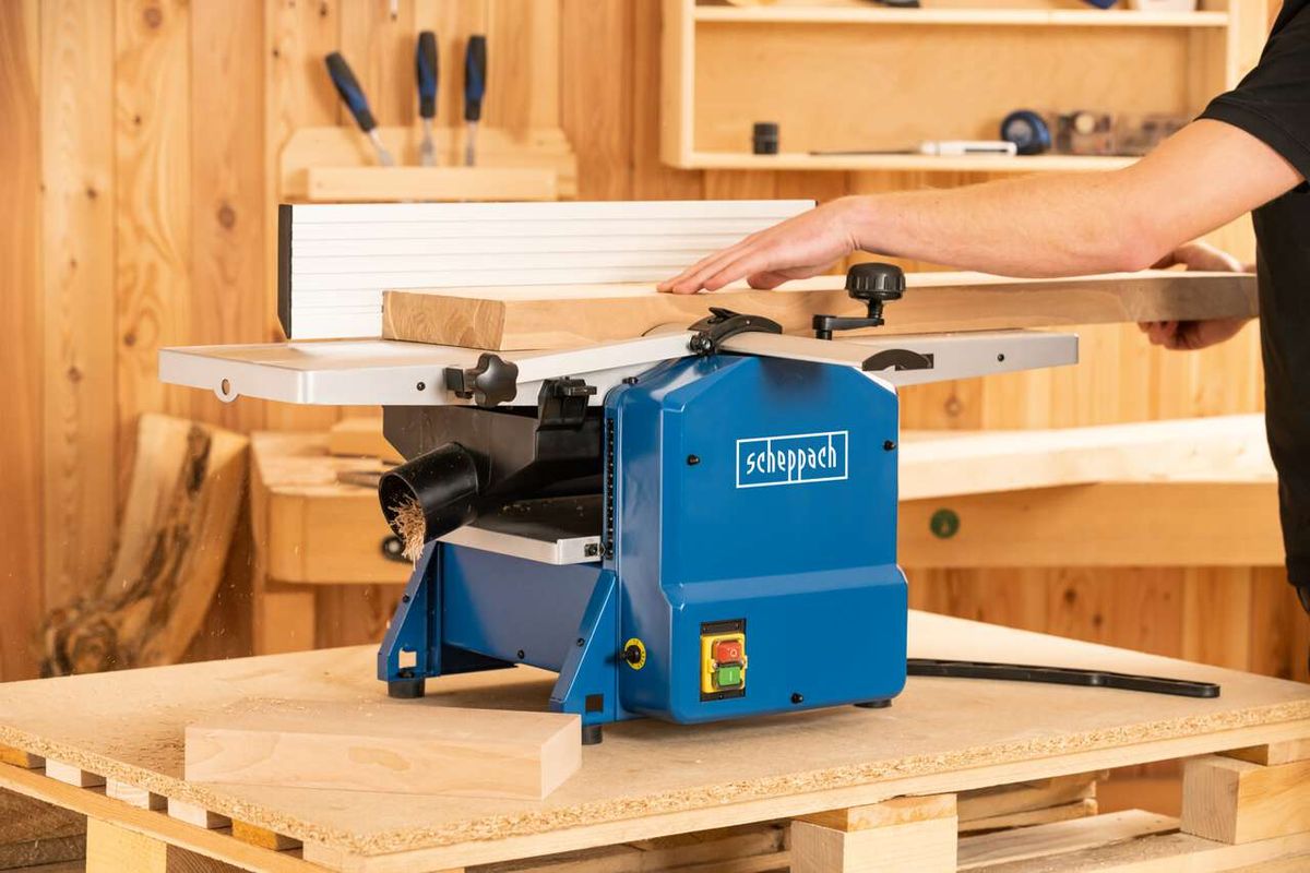 Abricht- & Dickenhobelmaschine HMS1070 Scheppach, 1500W, Hobelbreite 254mm, Höhe 120mm. Person bedient die Maschine in einer Werkstatt.