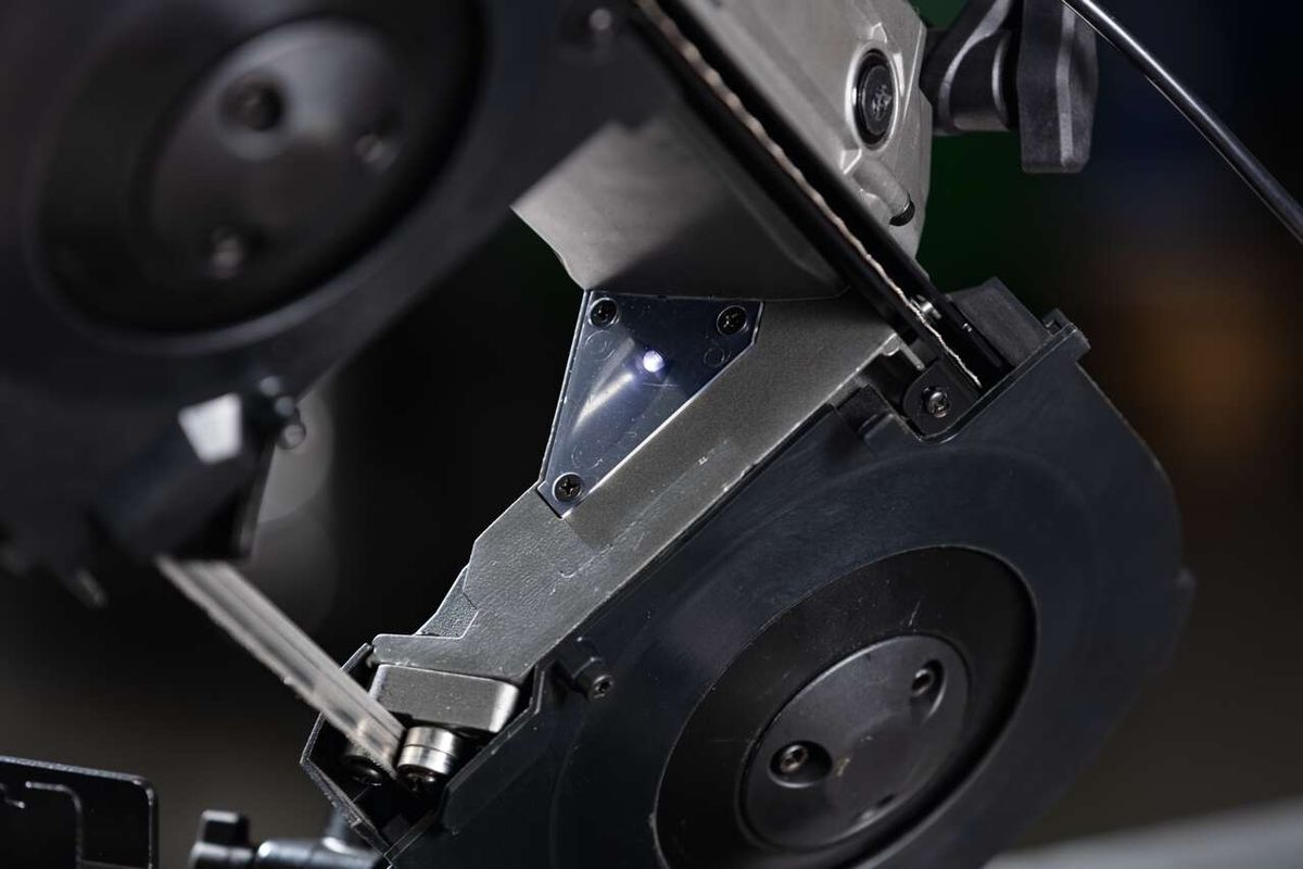 Metallbandsäge MBS1200xt Scheppach, Nahaufnahme des Sägeblatts. Die Sägeblat ist leicht gebogen und hat mehrere Schrauben. Die Sägeblat ist aus Metall. Die Sägeblat ist leicht gebogen und hat mehrere Schrauben. Die Sägeblat ist aus Metall.