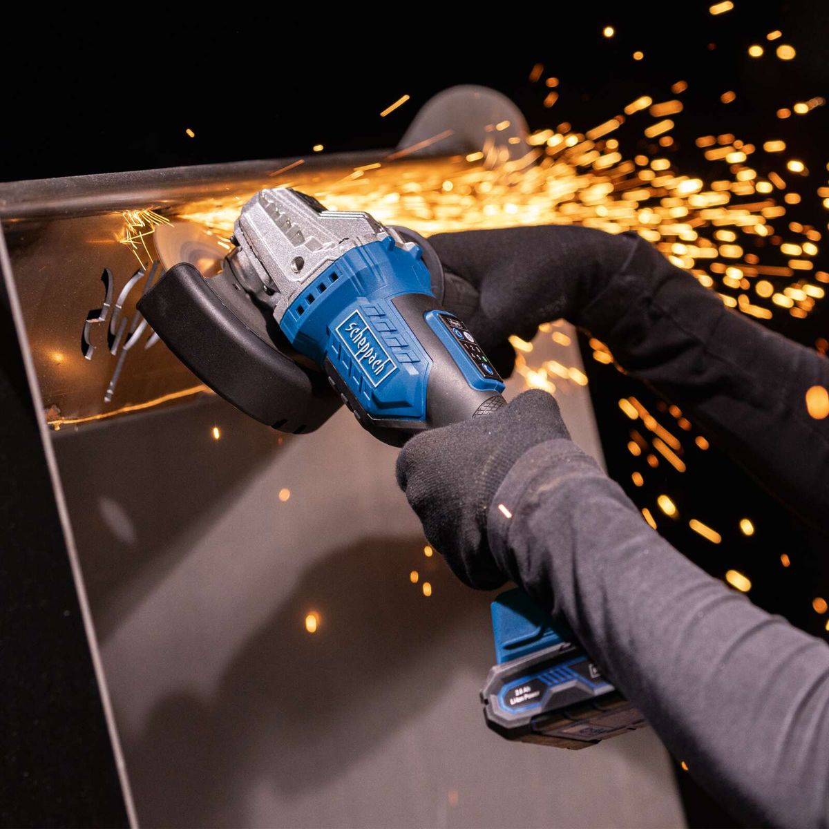 Handwerkskraft beim Arbeiten mit Akku-Winkelschleifer, sparkerfreie Bearbeitung