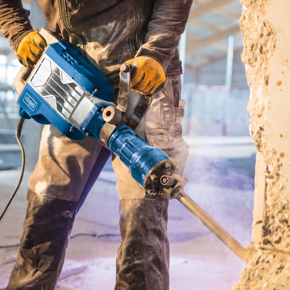 Elektro-Abbruchhammer mit Schutzausrüstung beim Einsatz, Fokus auf Handhabung und Werkzeug