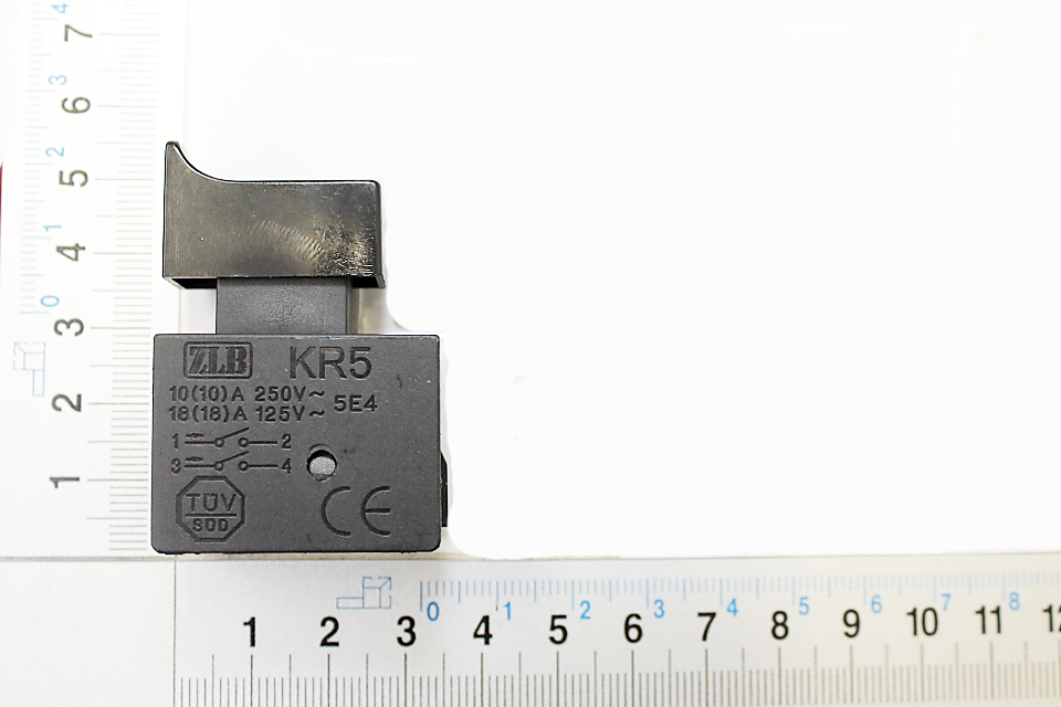 Schalter Ein/Aus 250V 10A KR-5, Ansicht von oben. Der Schalter liegt auf einem Lineal mit Zentimeter- und Millimeterskala.