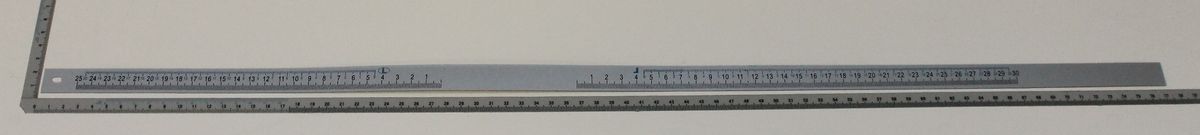 Ein 30-Zentimeter-Metalllineal mit Millimeter- und Zentimeter-Einteilung, von Scheppach. Das Lineal ist von der Seite zu sehen.
