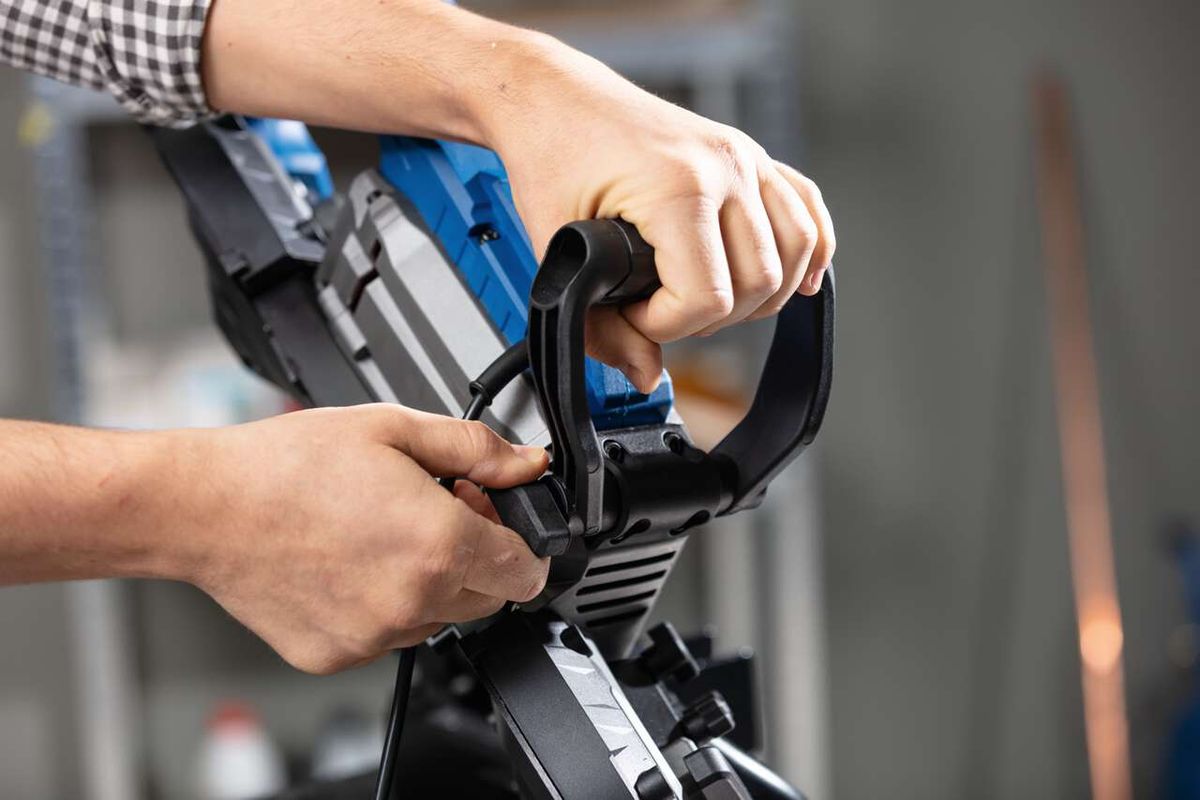 Metallbandsäge MBS1200xt Scheppach, Nahaufnahme des Handgriffs. Die Maschine wird von vorne gezeigt.