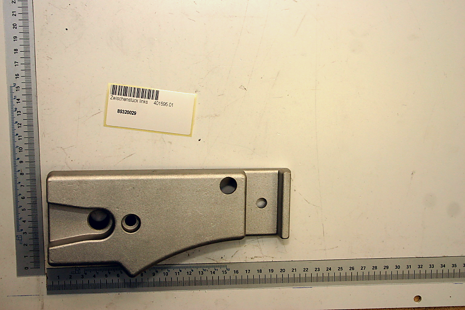 Zwischenstück links 401595.01, Artikelnummer 89320029. Gezeigt von vorne auf weißem Hintergrund.