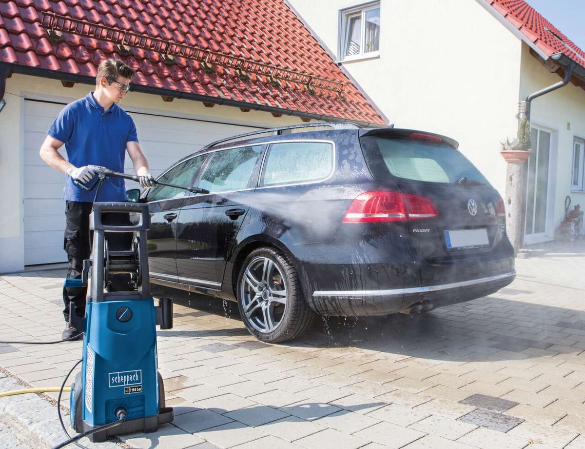 Ein Mann wäscht ein Auto mit dem Hochdruckreiniger HCE2000 von Scheppach. Der Reiniger hat 153 bar Druck und 2000W Leistung.