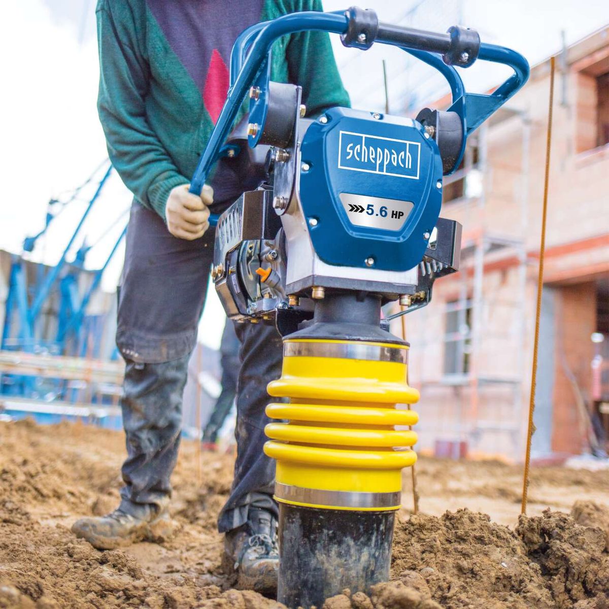 Der Scheppach Vibrationsstampfer VS1000 mit 5,6 PS und 10.000 Joule. Der Stampfer hat einen gelben Stoßdämpfer.