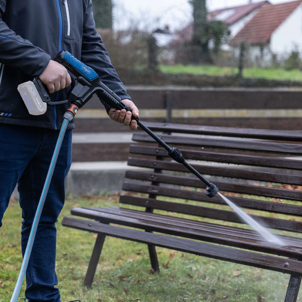 Person beim Reinigen mit Scheppach Akku-Druckreiniger, Schlauch angebracht