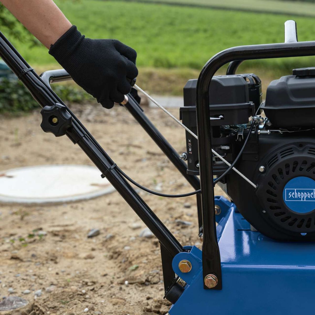 Scheppach vibrating plate with frame and control arm, showing handle and rubber mat detail