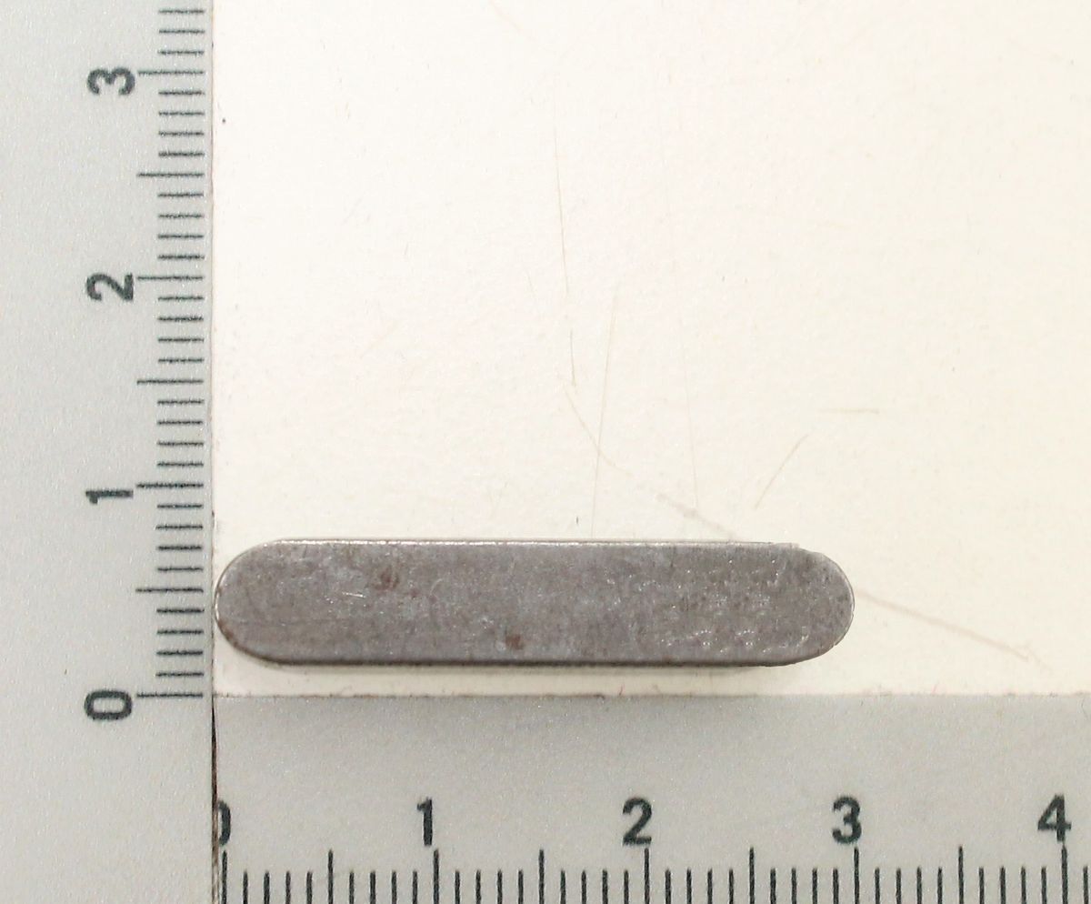 Passfeder A 6x6x30 / DIN 6885 C45 +C neben einem Lineal zur Größenveranschaulichung. Die Passfeder ist von links nach rechts ausgerichtet.