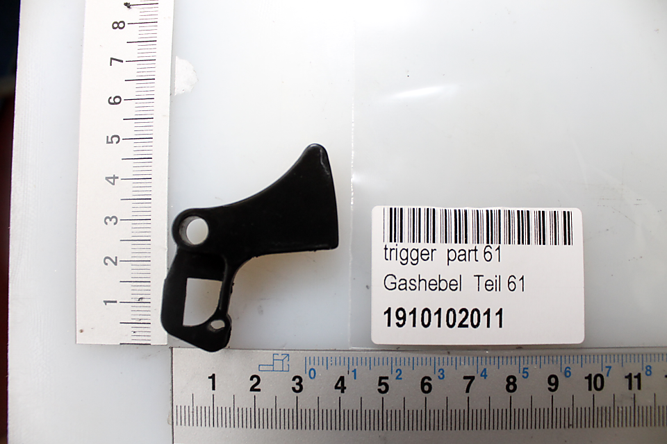 Ein schwarzer Auslösehebel, Teil 61, mit der Artikelnummer 1910102011. Der Hebel ist etwa 6 cm lang.