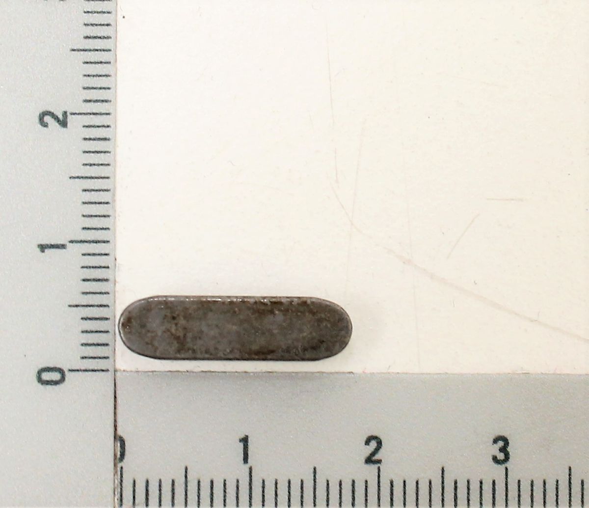 Passfeder A5x5x18 neben einem Lineal. Die Passfeder ist von der Seite zu sehen.